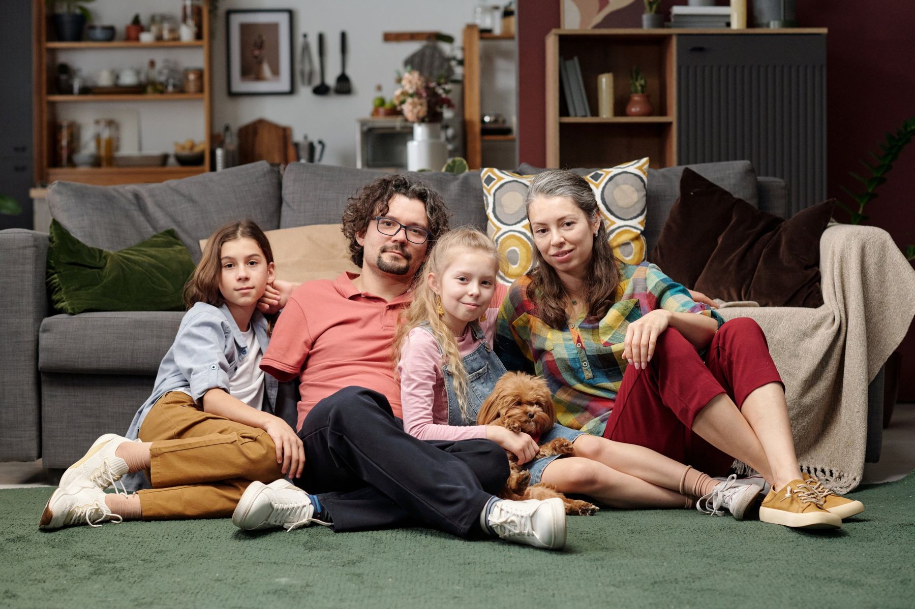 A family with two children and their dog in their living room