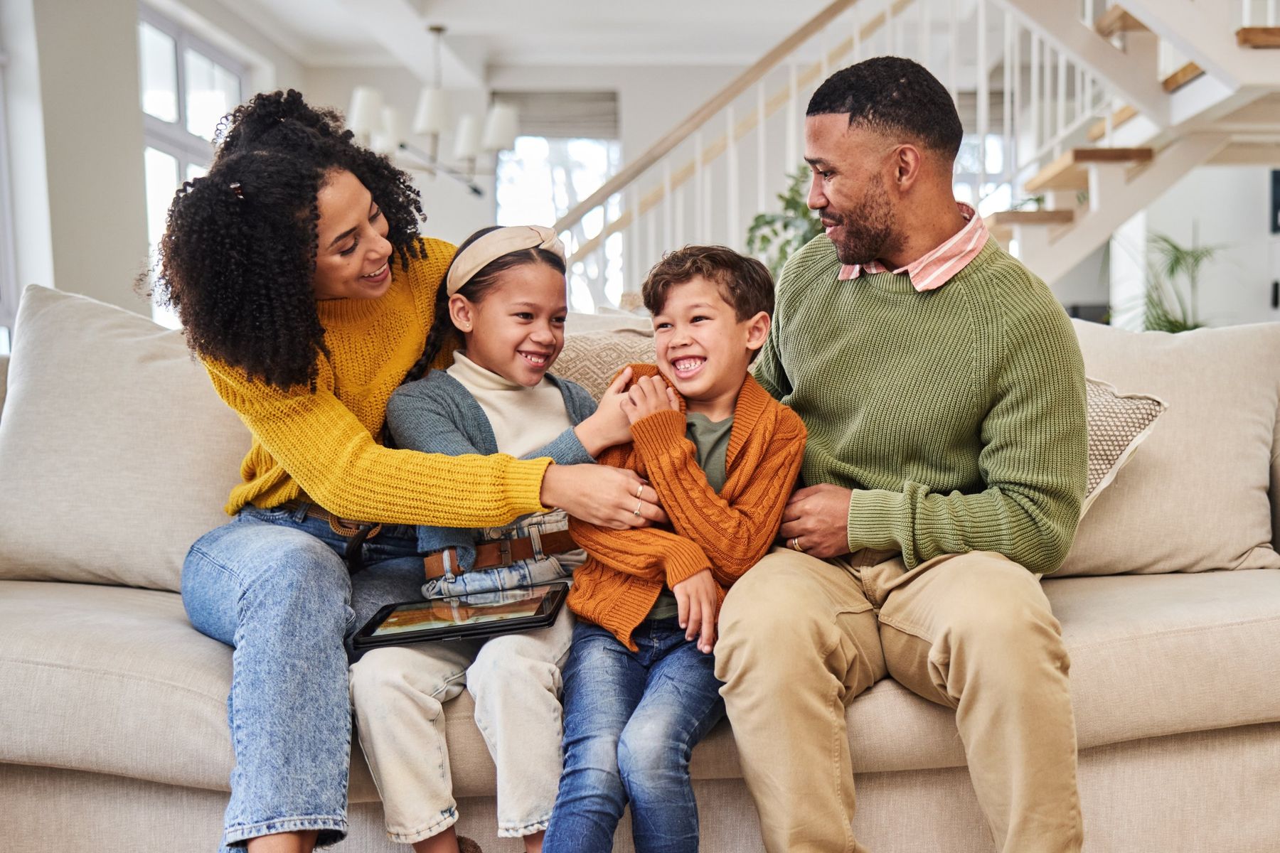 Parents and children laughing on a sofa